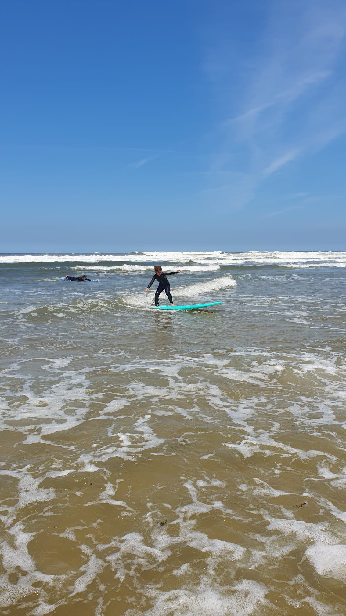 Child riding a small wave — beginner surf lessons Porto, Gaia, family surf Portugal