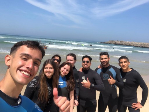 Friends in wetsuits selfie on the sand — surf lesson vibe Aguda near Porto, Okira community