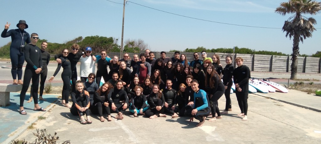 Surf school group in wetsuits posing together — team building surf Gaia, Praia surf Portugal